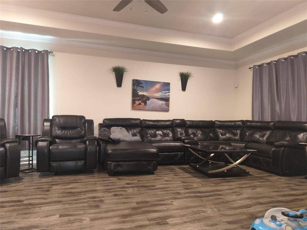3027 Ames Road, Lancaster, TX 75134 Spacious living area featuring wood-finish flooring, a tray ceiling, and crown molding