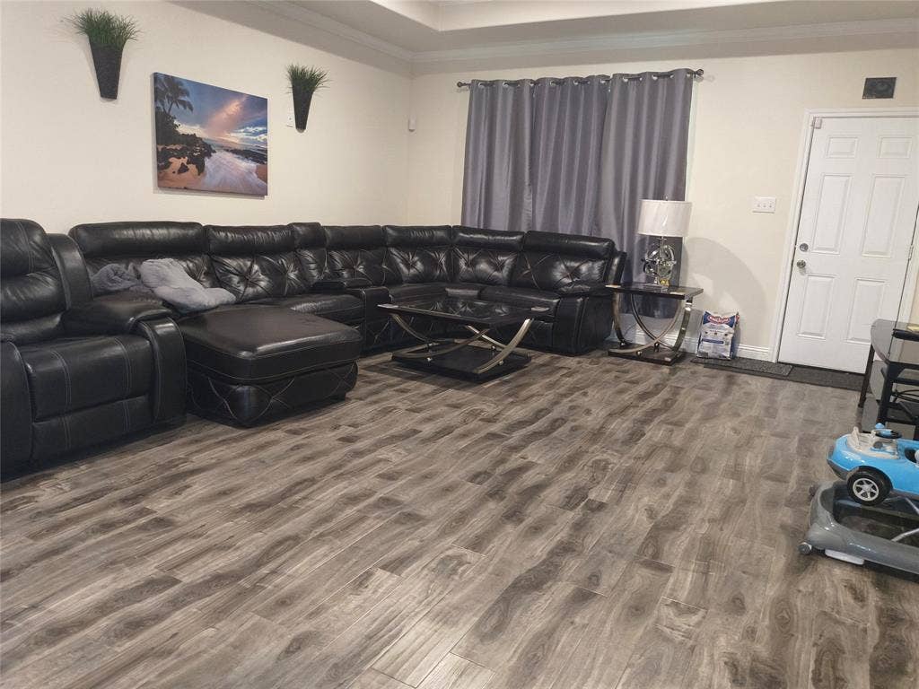 3027 Ames Road, Lancaster, TX 75134 Spacious room featuring wood-finish flooring, light neutral wall paint, and a white paneled entry door