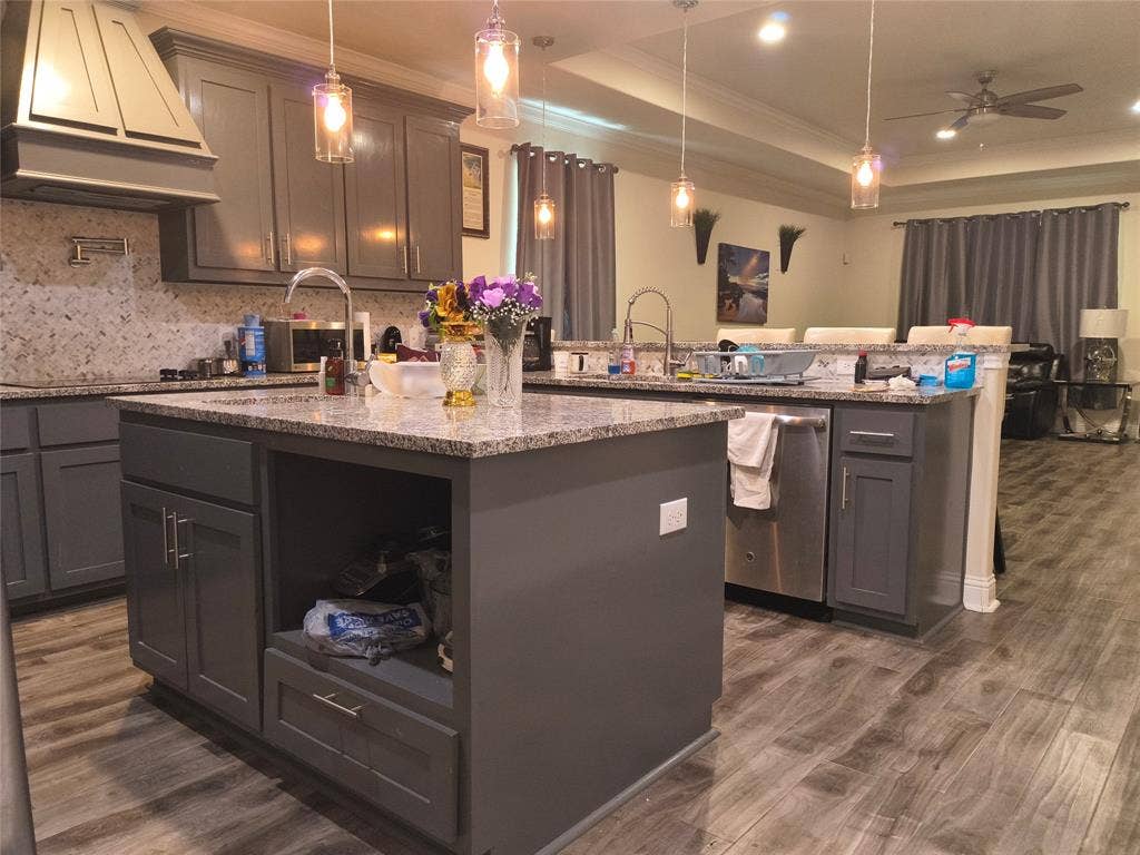 3027 Ames Road, Lancaster, TX 75134 Kitchen featuring a large island with an undermount sink, granite countertops, and grey cabinetry