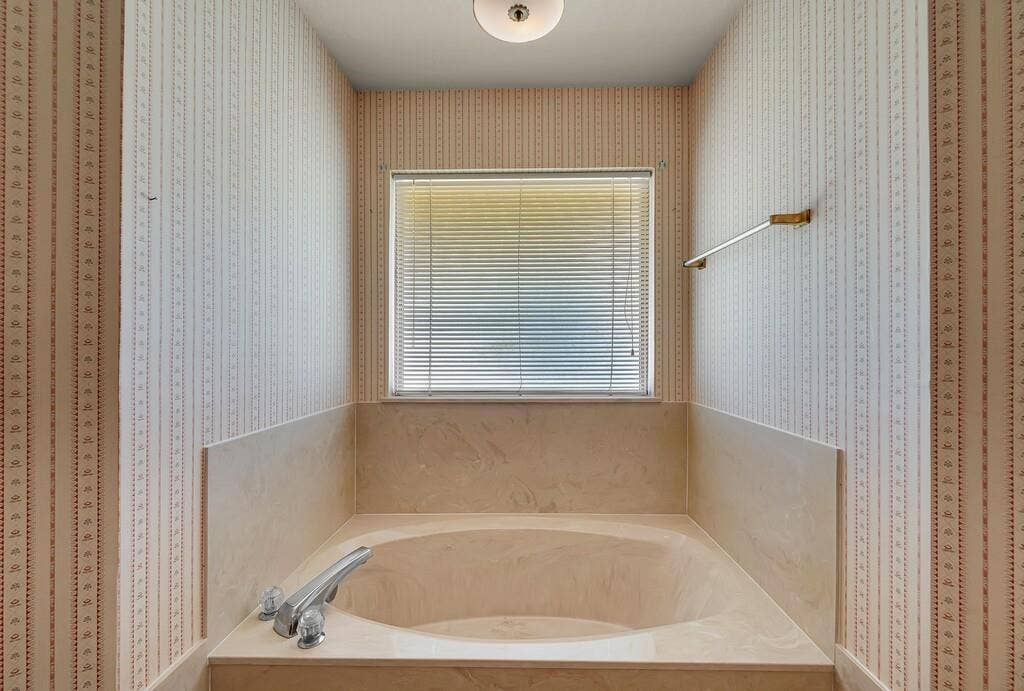 600 Lyndon Drive, Woodway, TX 76712 Built-in soaking tub with a light-toned surround, chrome fixtures, and a window featuring horizontal blinds