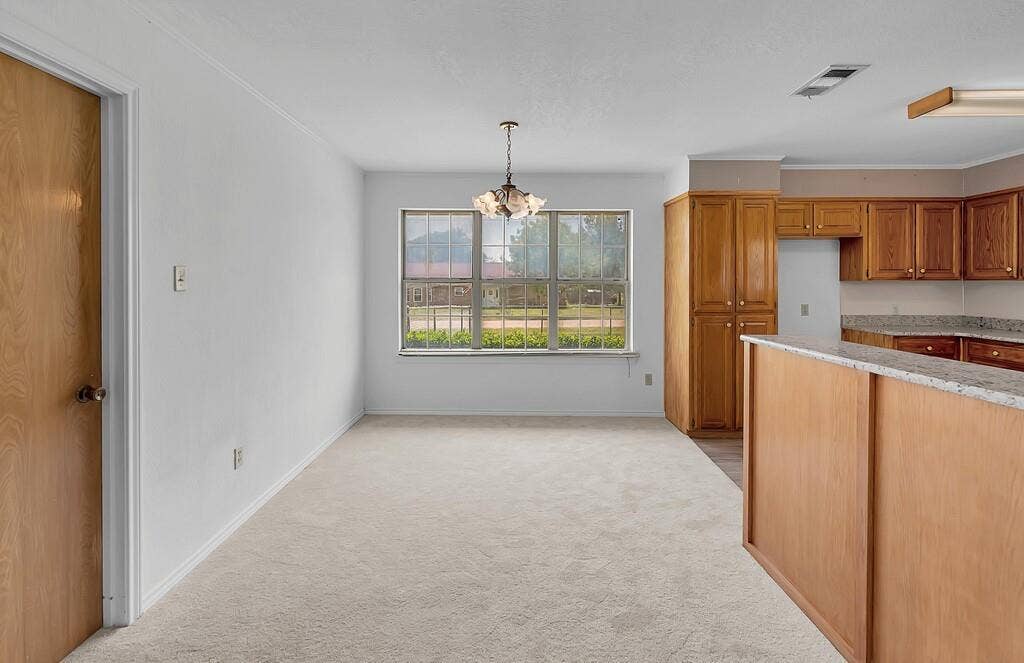 600 Lyndon Drive, Woodway, TX 76712 Bright interior space featuring light-colored carpeting, a multi-pane window, and a chandelier