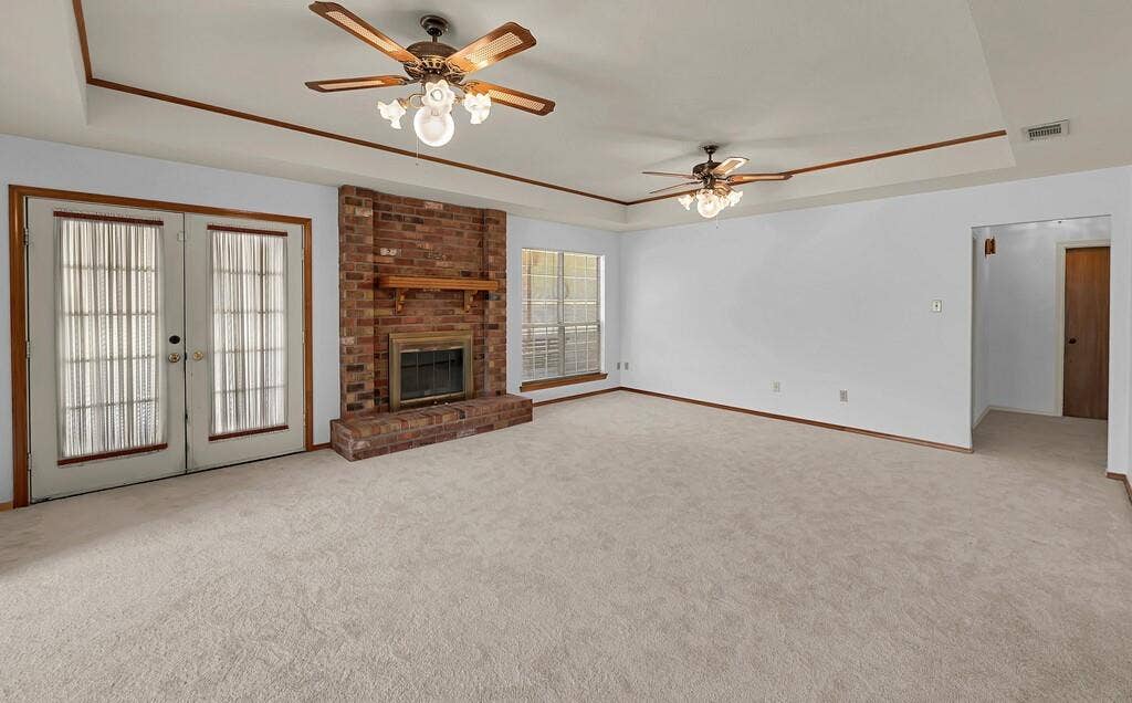 600 Lyndon Drive, Woodway, TX 76712 Spacious carpeted living area featuring a prominent brick fireplace with a wood mantel