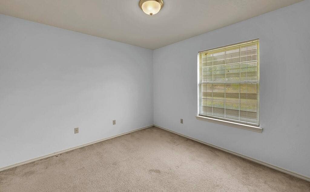 600 Lyndon Drive, Woodway, TX 76712 Room featuring neutral carpet flooring, light-toned wall paint, a single window with horizontal blinds, and an overhead flush-mount light fixture