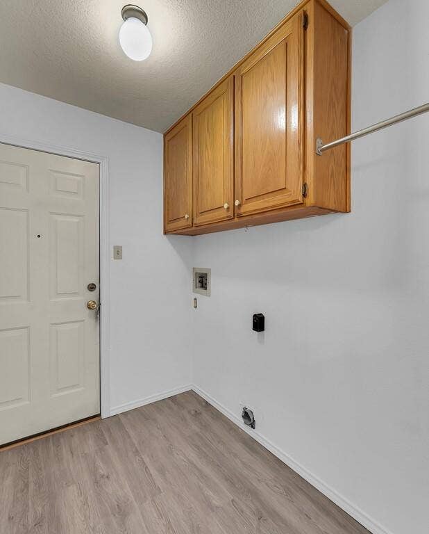 600 Lyndon Drive, Woodway, TX 76712 Utility area with wood-finish flooring, white walls, and a white paneled door