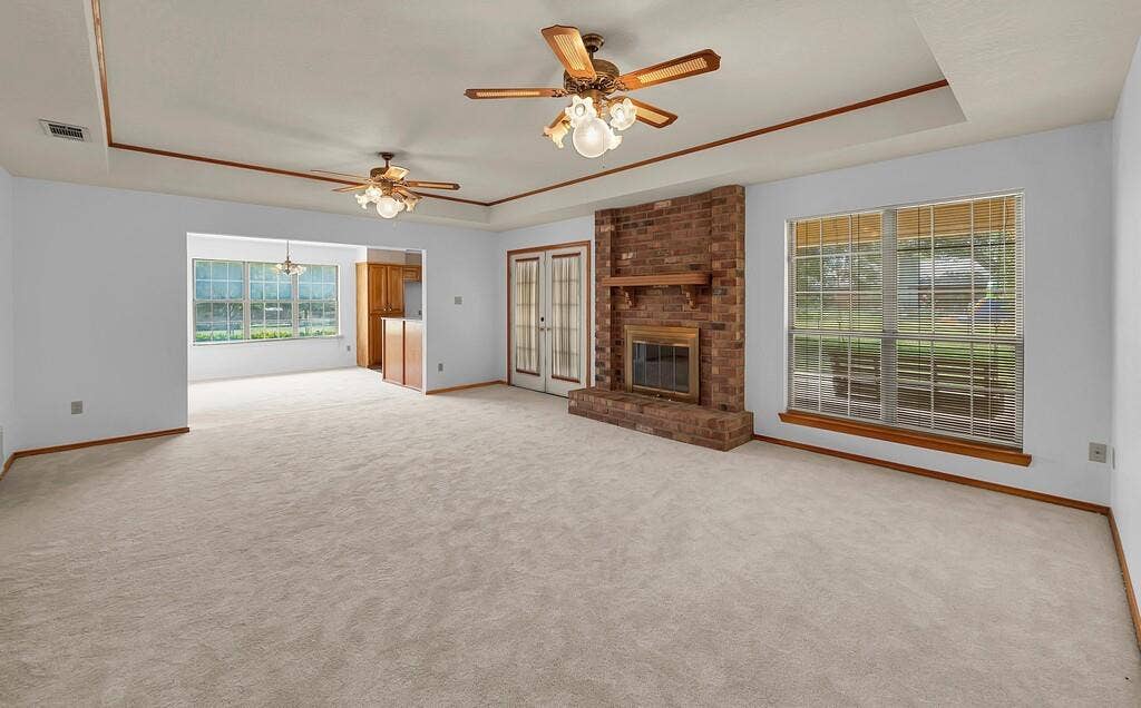 600 Lyndon Drive, Woodway, TX 76712 Spacious living room anchored by a brick fireplace with wood mantel, offering abundant natural light through multiple large windows