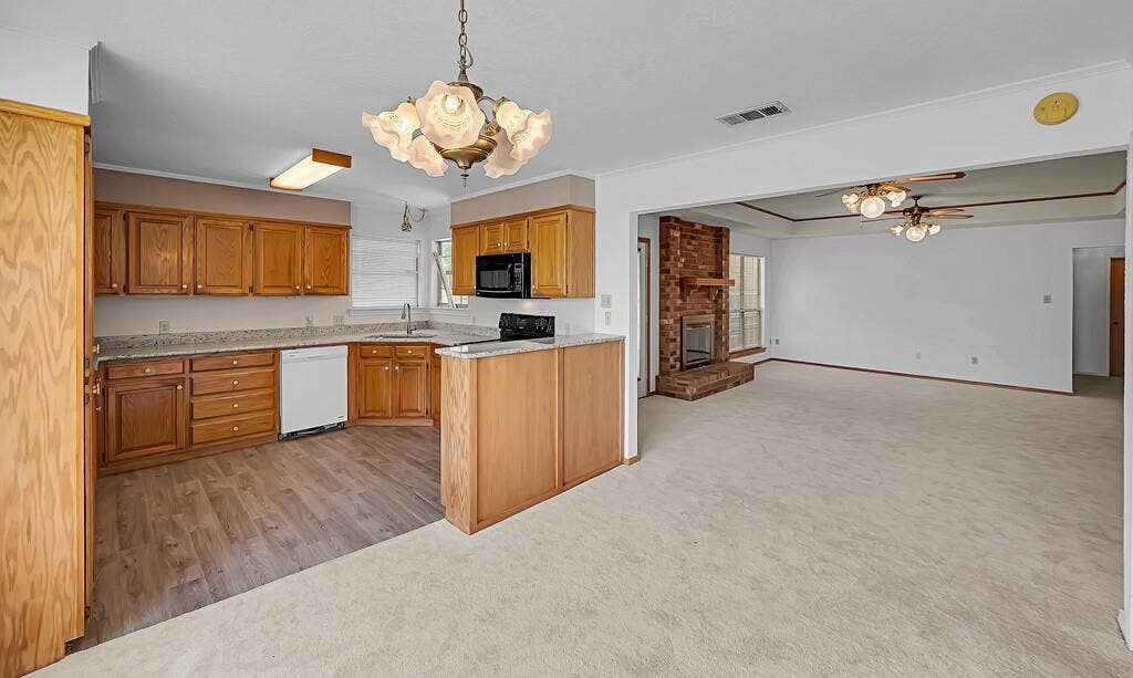 600 Lyndon Drive, Woodway, TX 76712 Open-concept kitchen and living area featuring wood-finish cabinetry, light-toned countertops, and integrated appliances