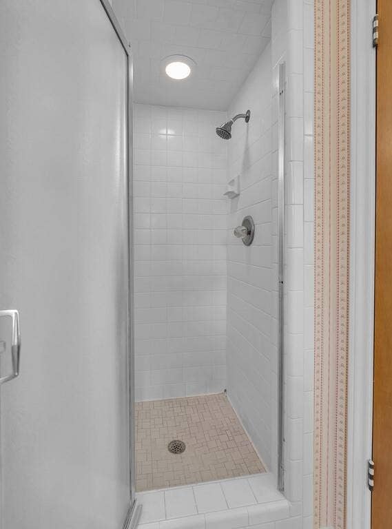 600 Lyndon Drive, Woodway, TX 76712 Enclosed shower featuring white subway tile walls, a mosaic tile shower pan, and a brushed nickel shower head
