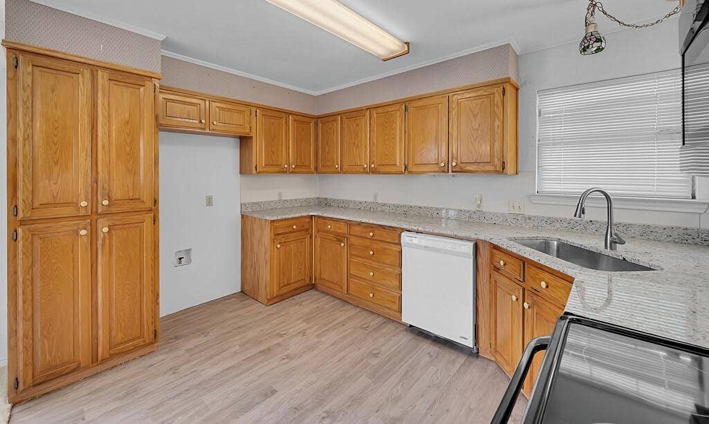 600 Lyndon Drive, Woodway, TX 76712 Spacious kitchen featuring warm wood-finish cabinetry throughout, granite countertops, stainless steel appliances including a dishwasher and electric range, and a large pantry with double doors