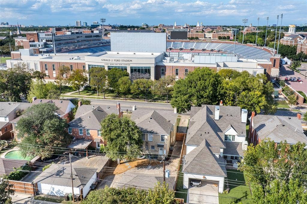 Aerial perspective of residential properties featuring multi-level rooflines, composite shingle roofing, private driveways, and mature landscaping