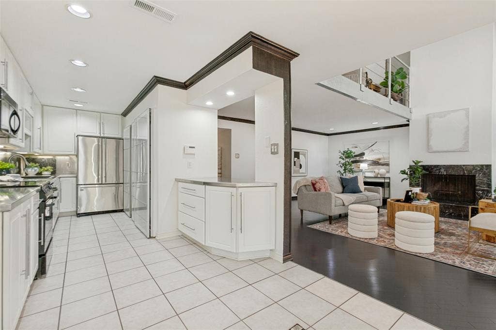 6362 Southpoint Drive, Dallas, TX 75248 Galley kitchen featuring white cabinetry, stainless steel appliances, and tile flooring