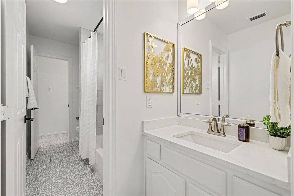 7904 Alderwood Place, Plano, TX 75025 Bathroom featuring a single vanity with an integrated sink, polished chrome faucet, and white countertop