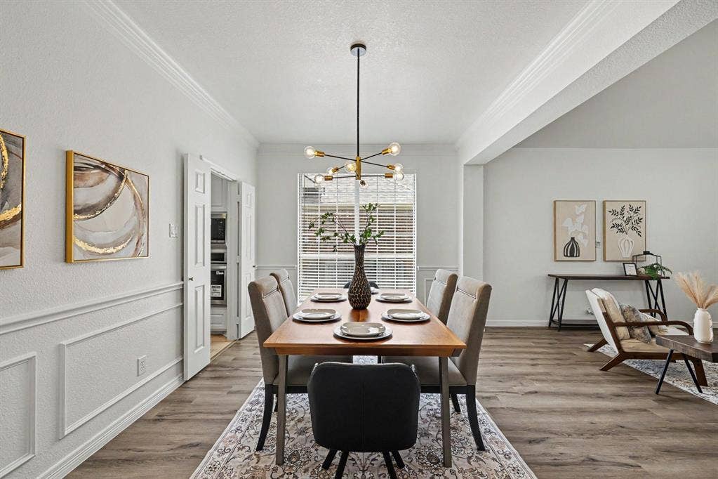 7904 Alderwood Place, Plano, TX 75025 Dining space featuring wood-finish flooring, wainscoting, and crown molding
