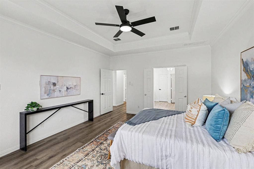 7904 Alderwood Place, Plano, TX 75025 Spacious room featuring wood-finish flooring, a tray ceiling, and a ceiling fan with integrated lighting