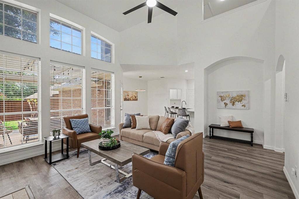 7904 Alderwood Place, Plano, TX 75025 Living area featuring high ceilings, wood-finish flooring, and arched architectural details