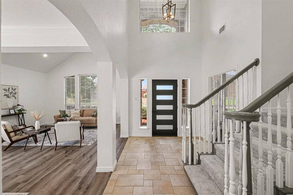 7904 Alderwood Place, Plano, TX 75025 Two-story entryway with tiled flooring and a carpeted staircase featuring white balusters and gray handrails