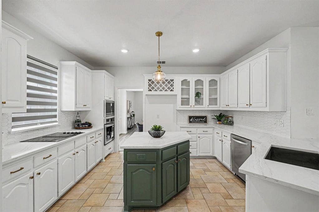 7904 Alderwood Place, Plano, TX 75025 Spacious kitchen featuring white cabinetry, light-toned countertops, and a central island with a contrasting green base