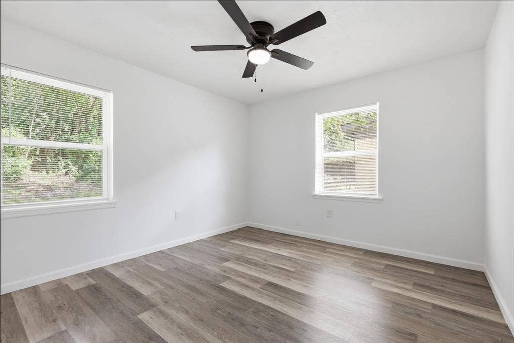 810 N Carrier Parkway, Grand Prairie, TX 75050 Room featuring wood-finish flooring, white walls, and a ceiling fan with integrated lighting