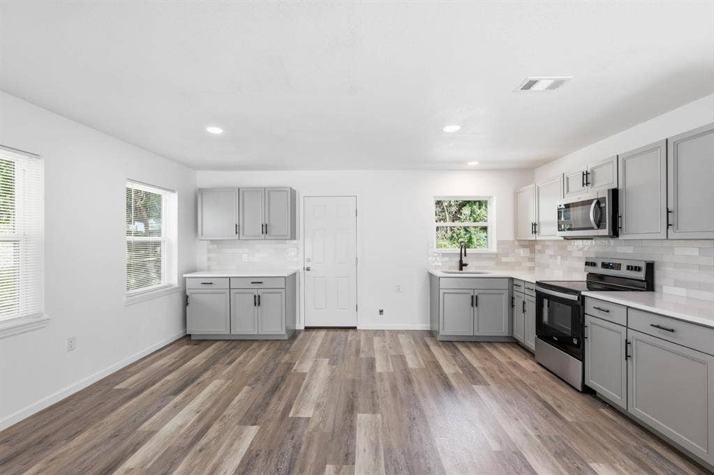810 N Carrier Parkway, Grand Prairie, TX 75050 Spacious kitchen featuring wood-finish flooring, white walls, and recessed lighting