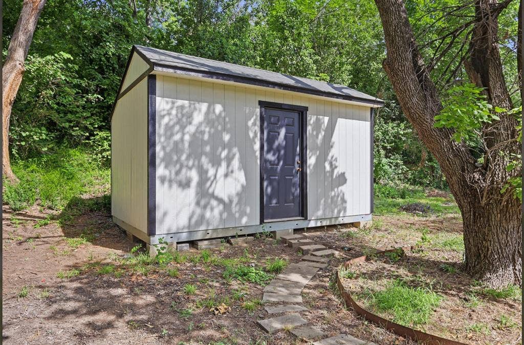 810 N Carrier Parkway, Grand Prairie, TX 75050 Detached storage shed with a dark gray door and black trim