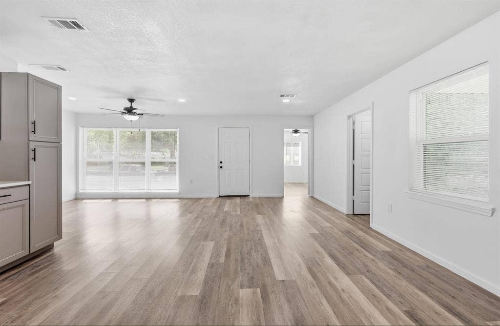 810 N Carrier Parkway, Grand Prairie, TX 75050 Spacious open-concept living area featuring wood-finish flooring, recessed lighting, and a ceiling fan