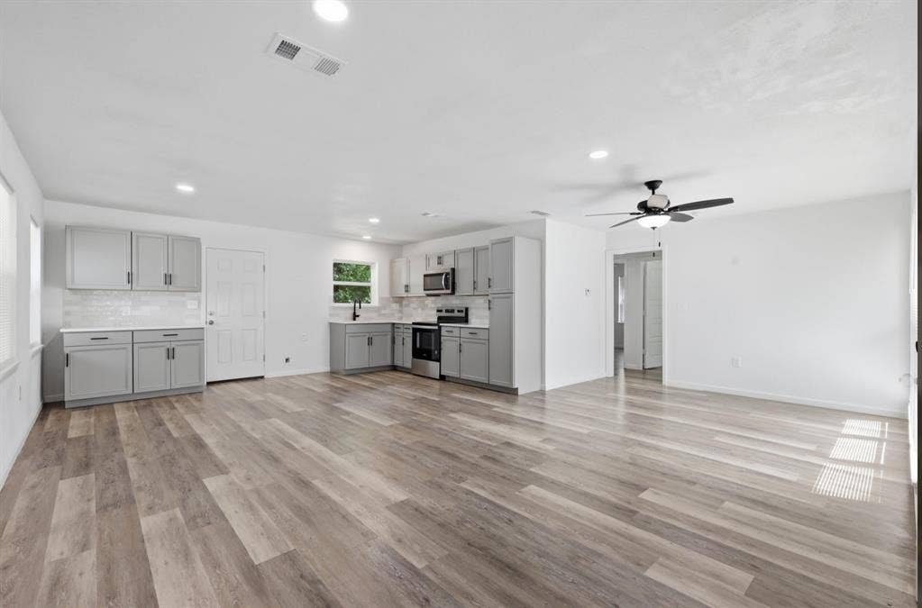 810 N Carrier Parkway, Grand Prairie, TX 75050 Open-concept living space featuring wood-finish flooring, recessed lighting, and a ceiling fan