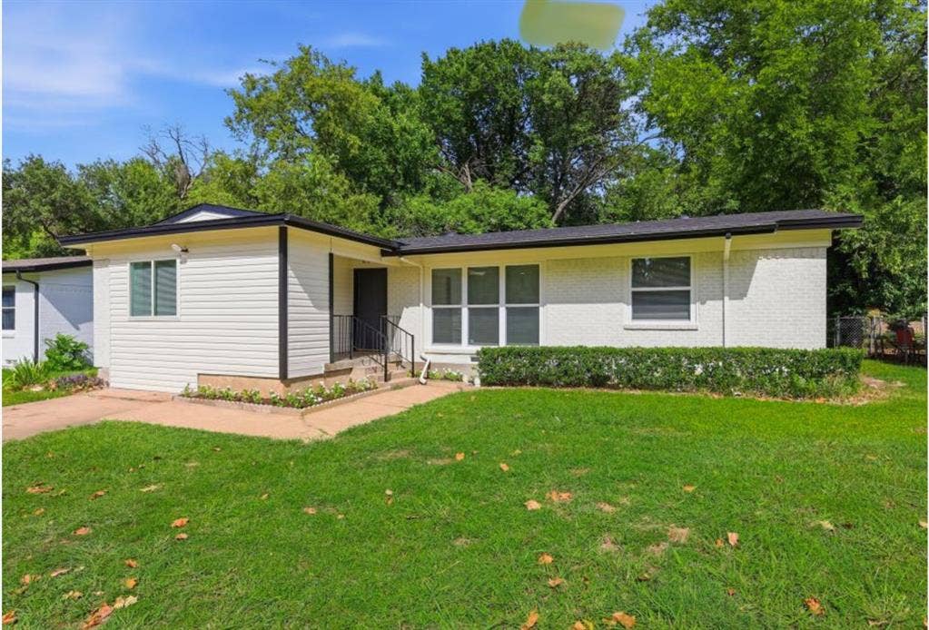 810 N Carrier Parkway, Grand Prairie, TX 75050 Contemporary facade featuring white siding and painted brick, dark trim accents, a dark front door, and a well-maintained lawn