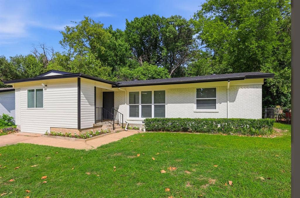 810 N Carrier Parkway, Grand Prairie, TX 75050 Single-story residence featuring a white brick and horizontal siding exterior