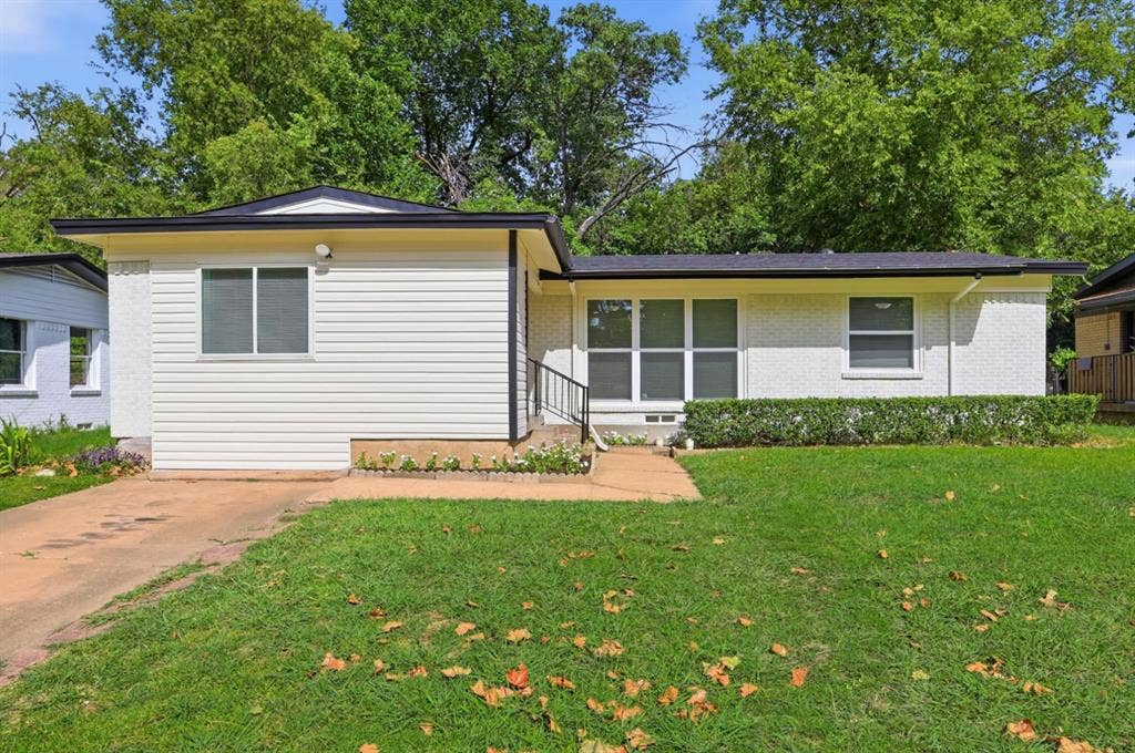 810 N Carrier Parkway, Grand Prairie, TX 75050 Single-story residence featuring a combination of white siding and painted brick exterior