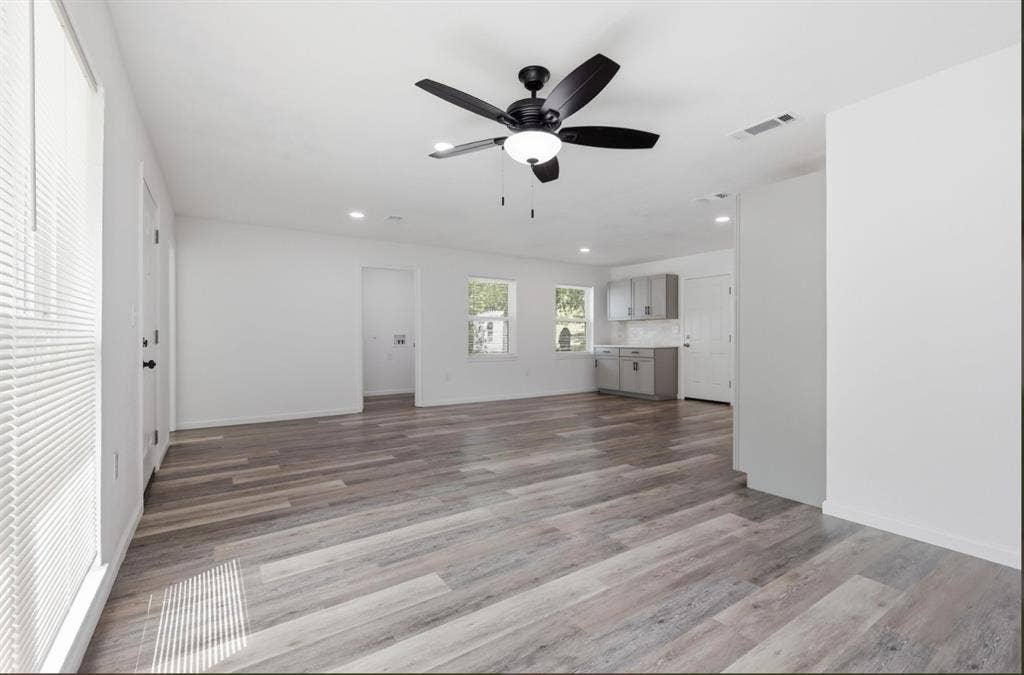 810 N Carrier Parkway, Grand Prairie, TX 75050 Spacious room featuring wood-finish flooring, recessed lighting, and a contemporary ceiling fan