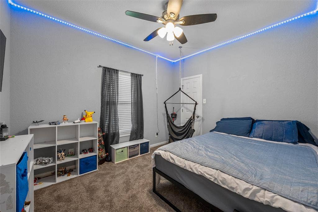 215 Greenbriar Street, Robinson, TX 76706 Carpeted room with a ceiling fan light fixture, overhead accent lighting, and a window with blinds