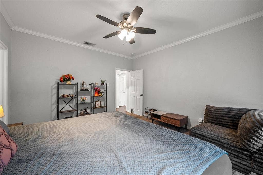 215 Greenbriar Street, Robinson, TX 76706 Spacious interior featuring a ceiling fan, white crown molding, wood-finish flooring, and light gray wall paint