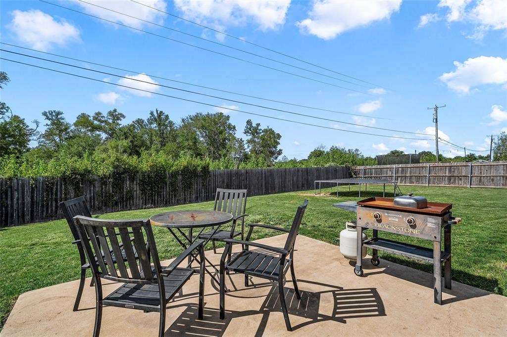 215 Greenbriar Street, Robinson, TX 76706 Expansive backyard featuring a concrete patio, grassy lawn, and wood privacy fencing