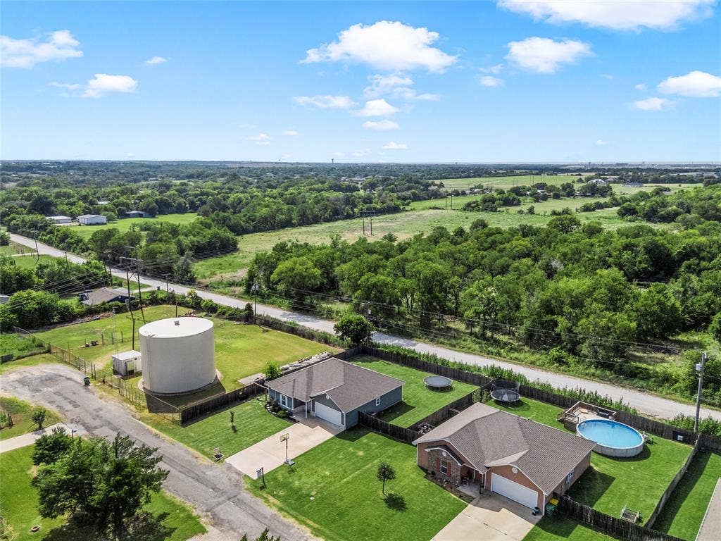 215 Greenbriar Street, Robinson, TX 76706 Aerial perspective showcasing two residential properties with expansive green surroundings