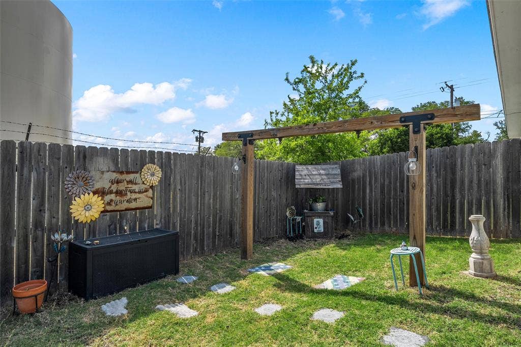 215 Greenbriar Street, Robinson, TX 76706 Private outdoor space featuring a full wood fence, a suspended wood beam structure, and stone pavers