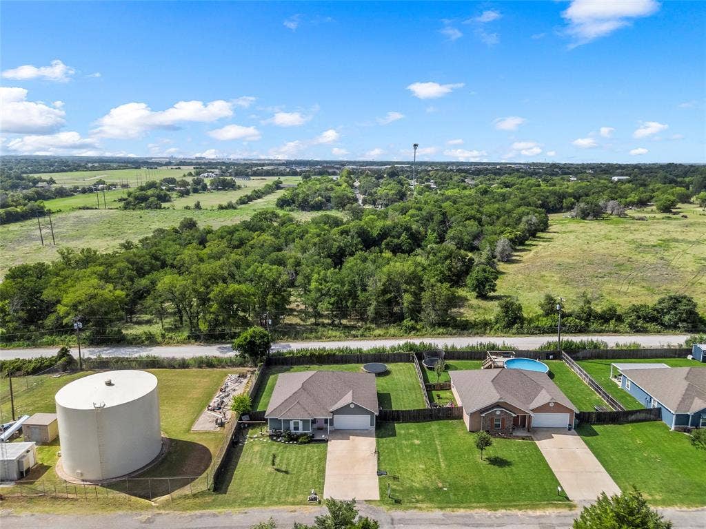 215 Greenbriar Street, Robinson, TX 76706 Aerial perspective showcasing a residential property with a brown-shingled roof and an attached two-car garage