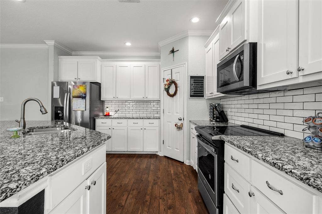 215 Greenbriar Street, Robinson, TX 76706 Bright kitchen featuring white cabinetry, granite countertops, and wood-finish flooring