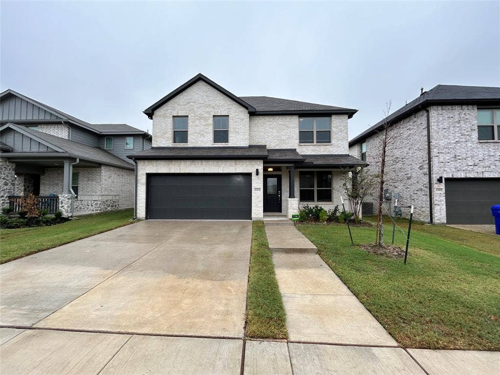 1323 Great Sand Dune Street, Royse City, TX 75189 Two-story residence featuring light-colored brick veneer and dark roof shingles