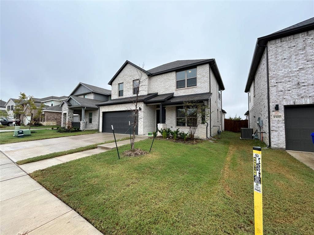 1323 Great Sand Dune Street, Royse City, TX 75189 Two-story residence featuring light-colored brick veneer and dark roof shingles