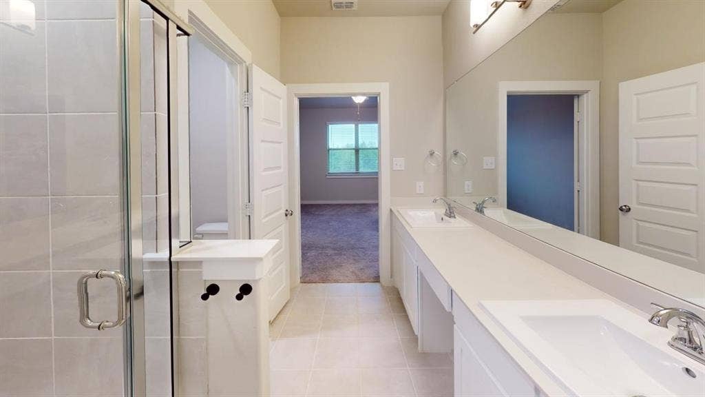 1323 Great Sand Dune Street, Royse City, TX 75189 Modern bathroom featuring a double vanity with integrated sinks, a full-width mirror, and chrome fixtures