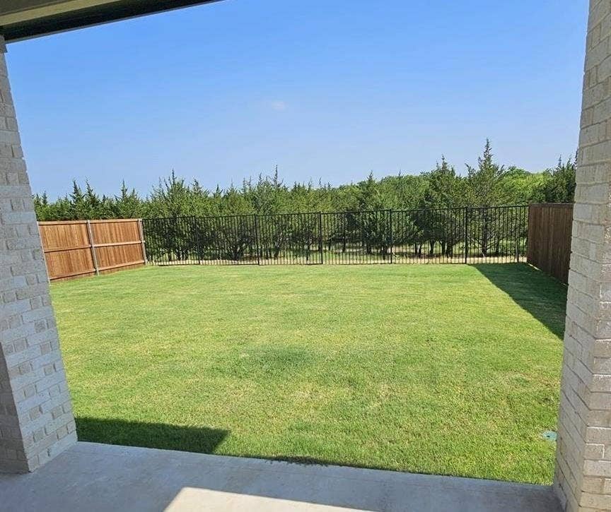 1323 Great Sand Dune Street, Royse City, TX 75189 Expansive rear yard featuring a manicured lawn and a combination of wood and wrought iron fencing