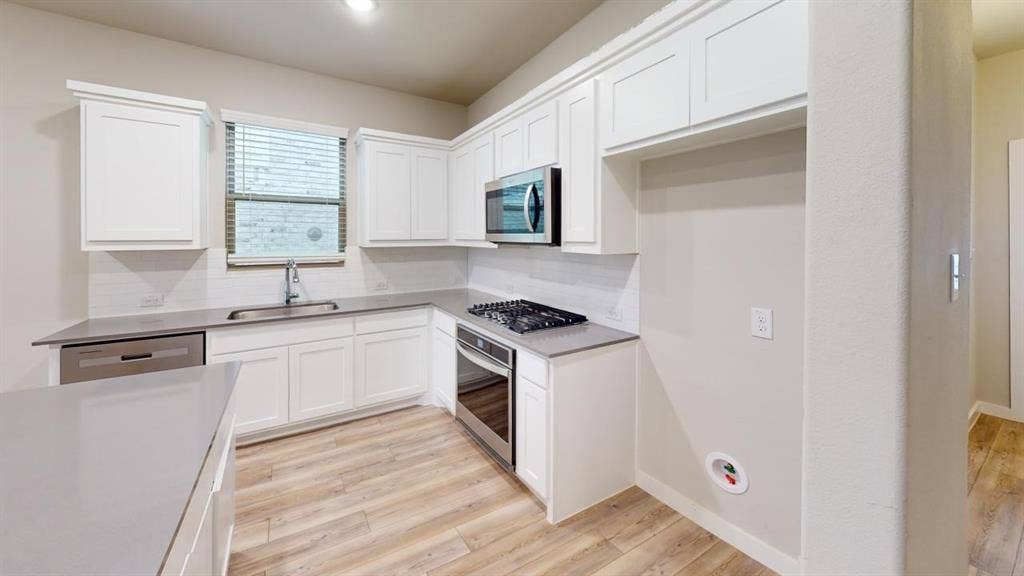 1323 Great Sand Dune Street, Royse City, TX 75189 Kitchen featuring white shaker-style cabinetry, light wood-finish flooring, and light-toned countertops