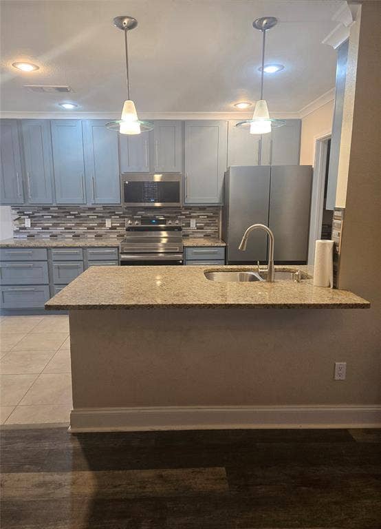1402 Signet Drive, Euless, TX 76040 Kitchen featuring granite countertops, light gray cabinetry, stainless steel appliances, and a tiled backsplash