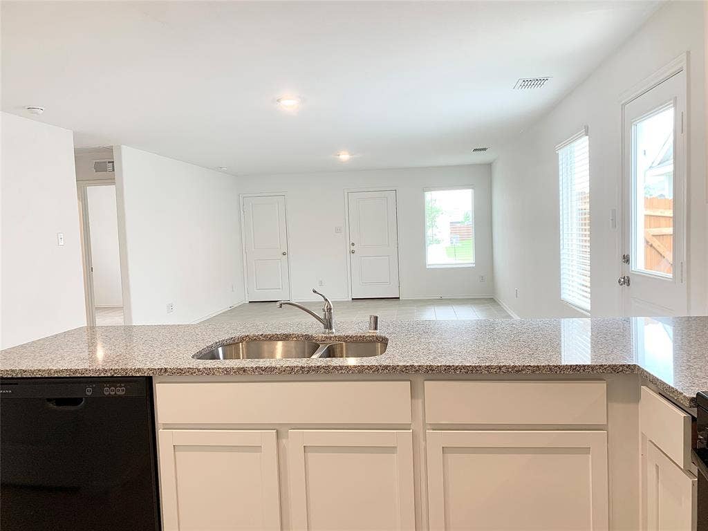 7212 Gray Wolf Lane, McKinney, TX 75071 Kitchen with sink, light stone countertops, dishwasher, and white cabinetry