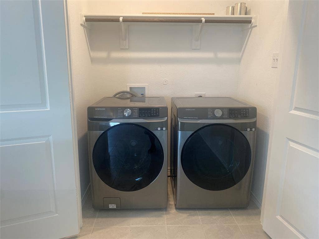 7212 Gray Wolf Lane, McKinney, TX 75071 Laundry room featuring washing machine and dryer and light tile patterned floors