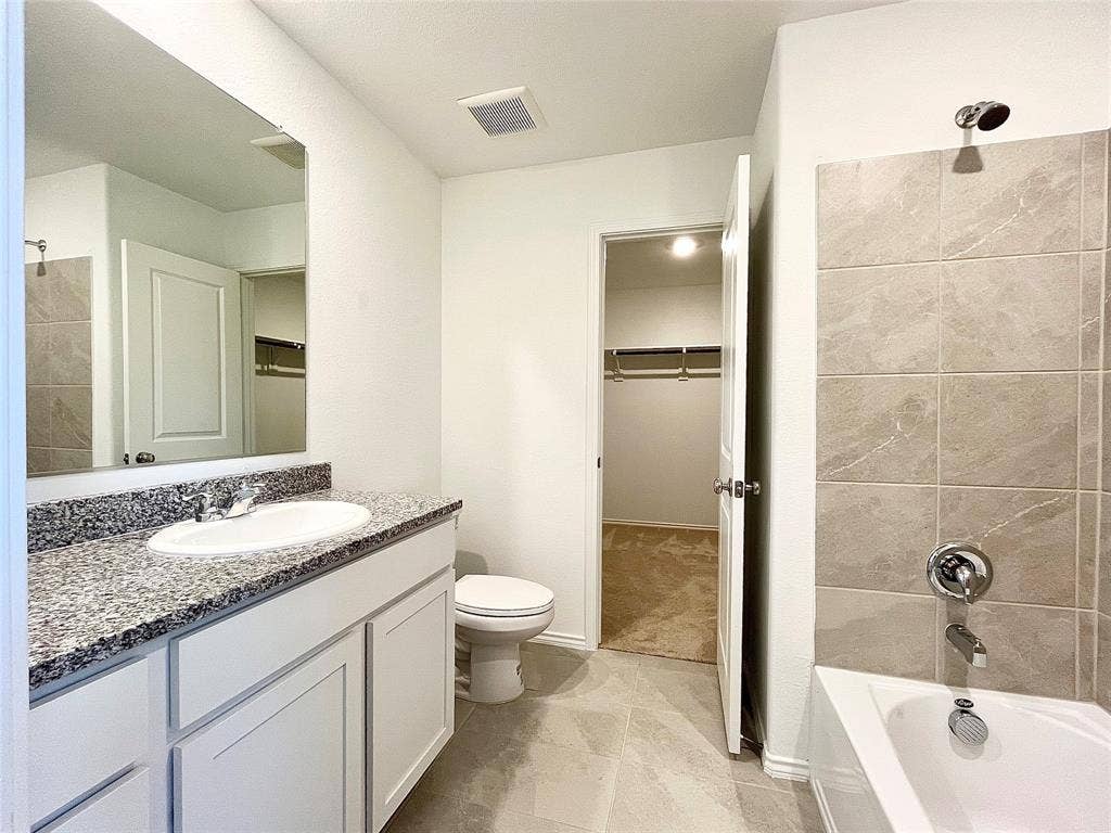 7212 Gray Wolf Lane, McKinney, TX 75071 Bathroom with vanity, bathing tub / shower combination, and a spacious closet