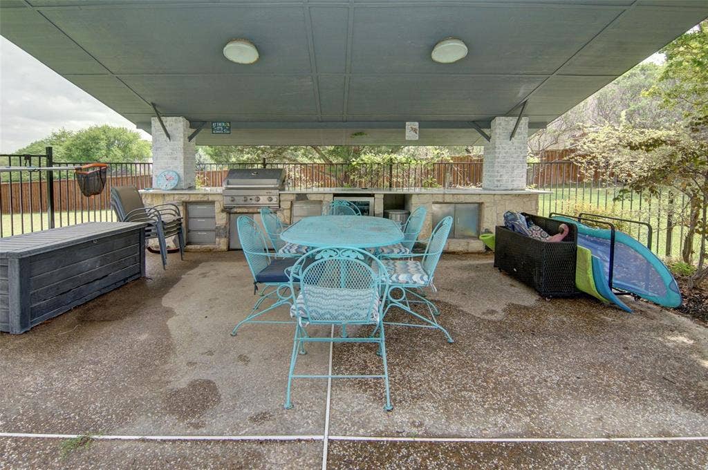 1202 Forest Park Drive, Weatherford, TX 76087 Pool-side cabana with outdoor kitchen including grill, beverage refrigerator, sink, and storage.