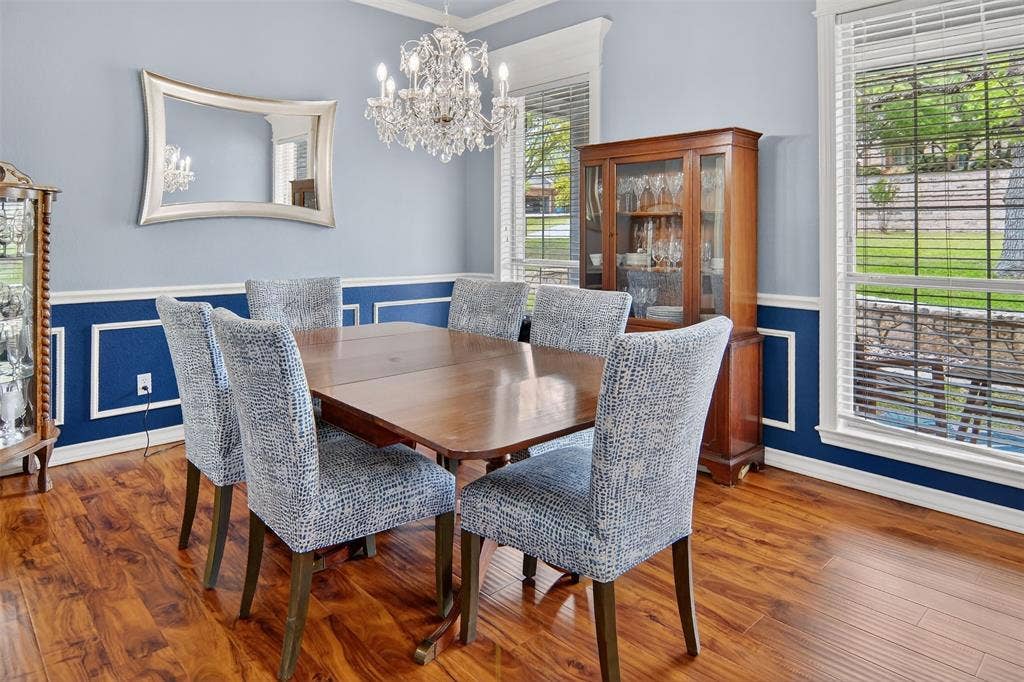 1202 Forest Park Drive, Weatherford, TX 76087 Spacious dining room with an elegant chandelier and wainscoting elevate every dinner.