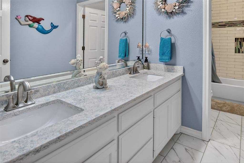 1202 Forest Park Drive, Weatherford, TX 76087 Second of three full bathrooms downstairs. Dual sinks and separate tub and toilet area are handy for multiple users at once.
