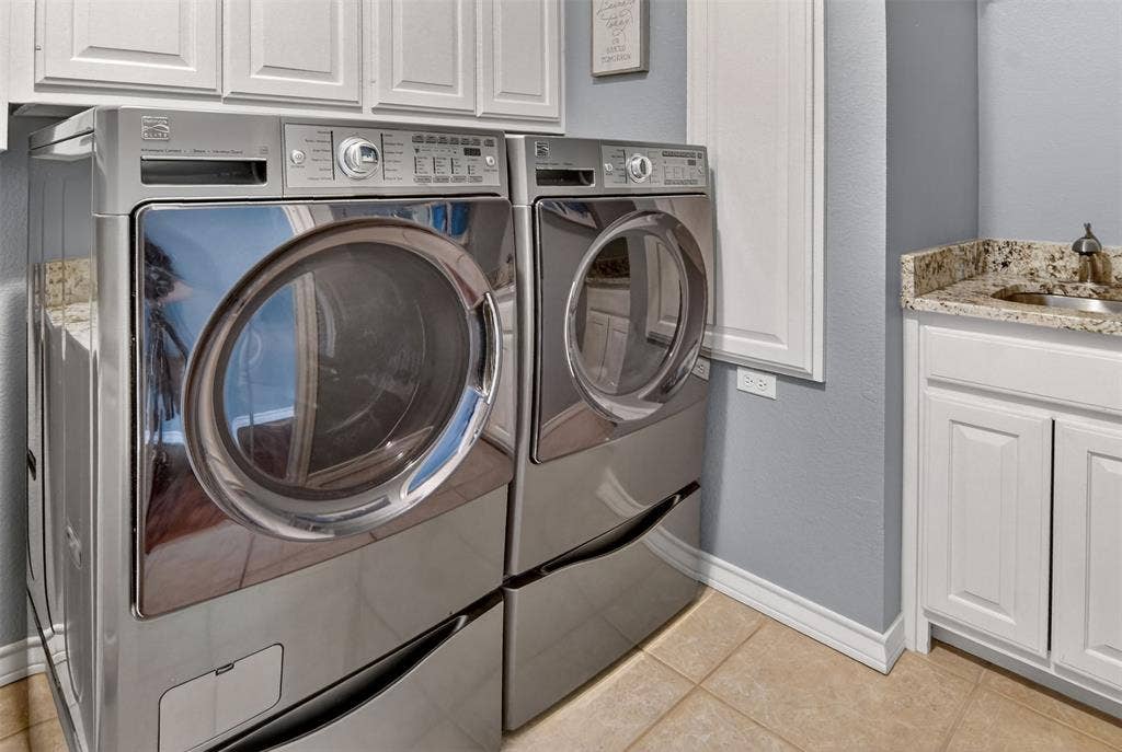 1202 Forest Park Drive, Weatherford, TX 76087 Laundry room with built-in cabinets, shelves, fold-out ironing board, and a sink.