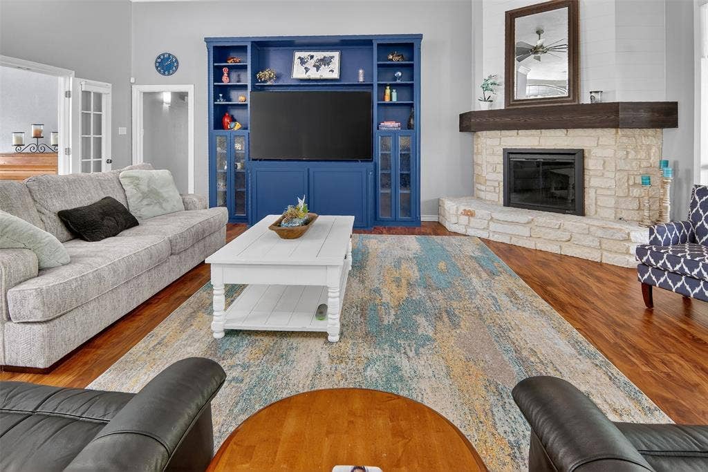 1202 Forest Park Drive, Weatherford, TX 76087 Built-in cabinetry and large, wood-burning, fireplace with gas starter, glass front, raised hearth, and heavy wood mantle.